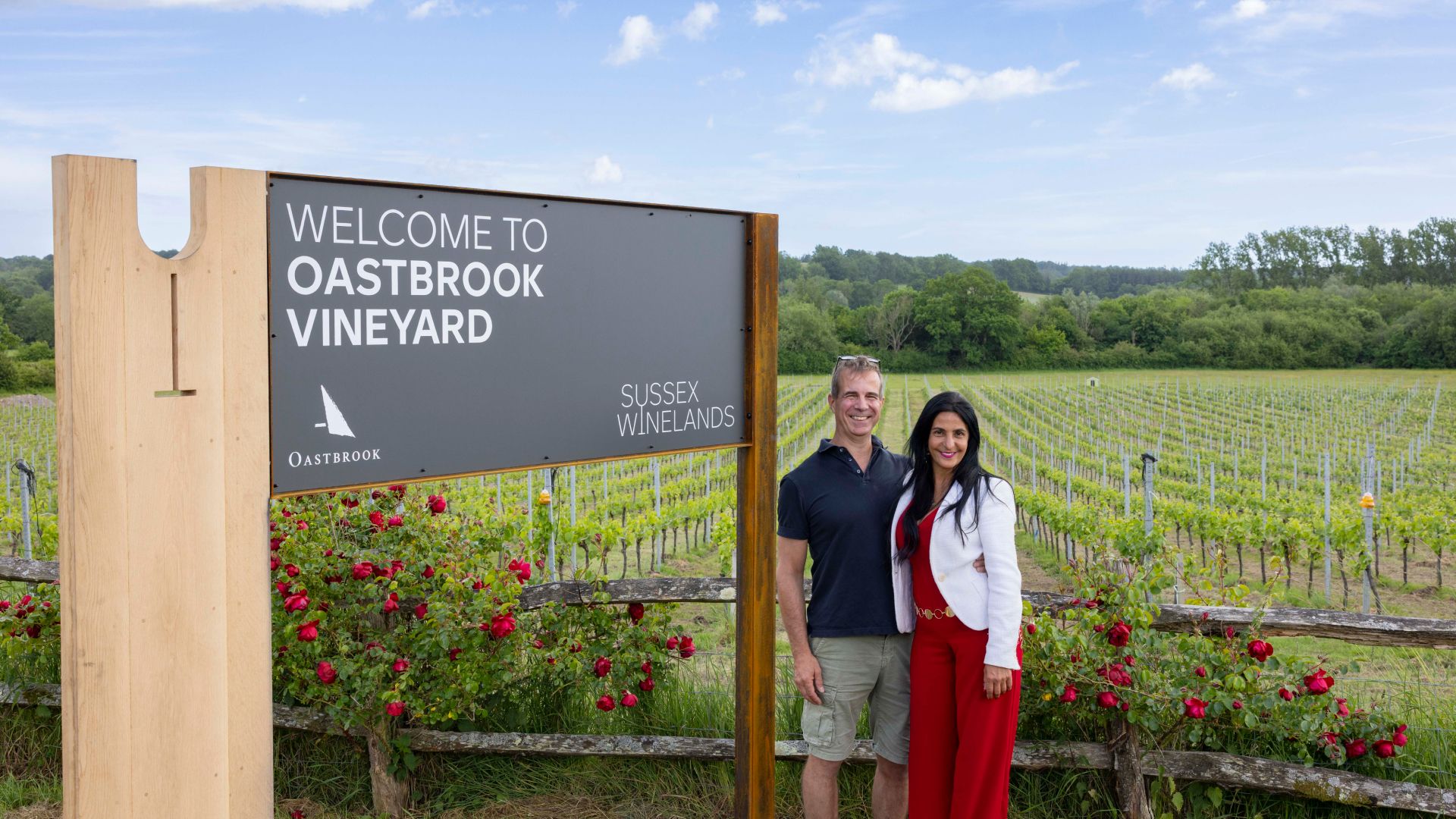 The family owners stood infront of the Sussex Winelands signage installed at Oastbrook Vineyard
